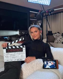 Molly Mae holding a clapperboard, announcing three new episodes of her show on May 9th.