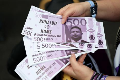 Real Valladolid fans protesting with fake 500 euro bills featuring Ronaldo's image.