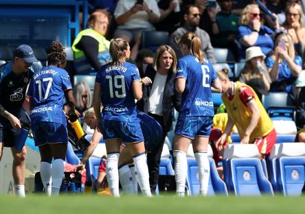 Chelsea manager Sonia Bompastor speaks with players during a break in play.