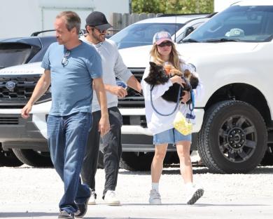 Sydney Sweeney and Jonathan Davino walking with a German Shepherd puppy.