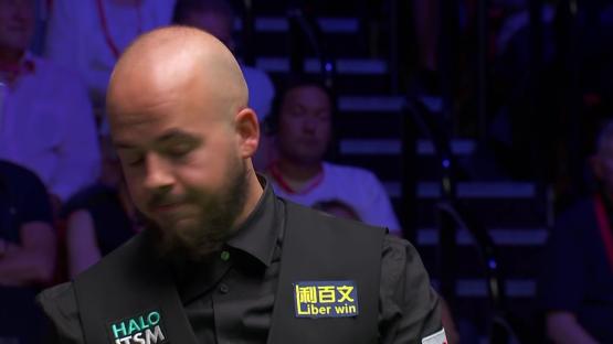 Luca Brecel apologizing to Judd Trump during a snooker match.