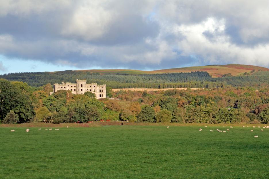 Dalquharran Castle ruins in a pastoral landscape.