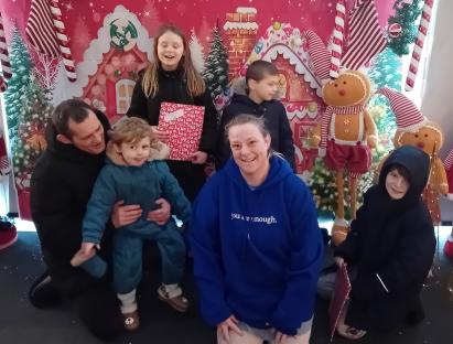 Family portrait in front of a Christmas backdrop.