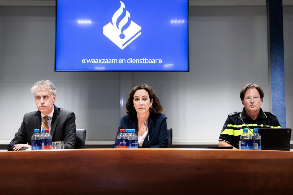 Three officials at a press conference.