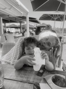 Black and white photo of a woman and child at an outdoor restaurant.