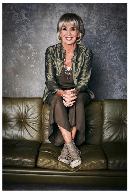 Sue Johnston, actress, sitting on a couch.