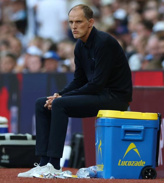 Thomas Tuchel sitting on a cooler during a soccer match.