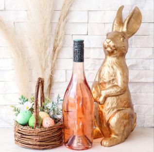 Rose wine bottle, Easter eggs, and gold rabbit decoration.