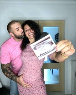 Pregnant Sonia Ibrahim and her partner holding an ultrasound image.