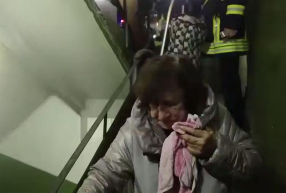 An elderly woman being evacuated from an apartment building in Kyiv after a Russian attack.