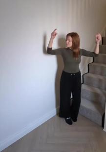 Woman gesturing towards hallway with new paneling.