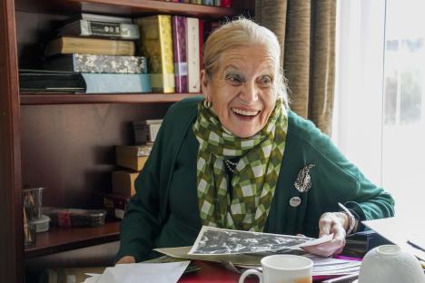 Smiling woman looking at photos, speaking at the Albert Hall on VE Day.