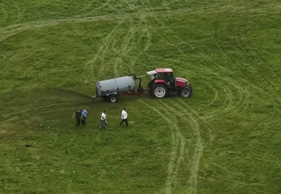 Tractor spreading fertilizer on a field.