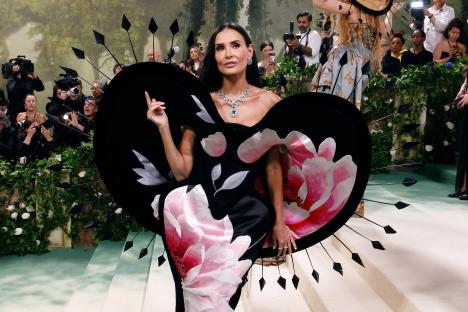 Demi Moore at the Met Gala wearing a black and pink floral gown.