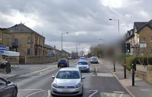 Street scene in Leeds with cars and buildings.