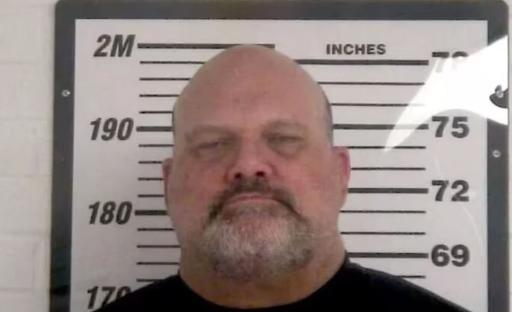 Mugshot of a balding man.