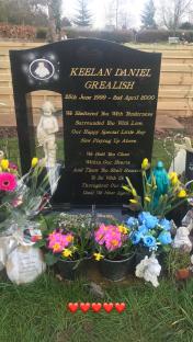 Photo of Keelan Daniel Grealish's gravestone with flowers and cherubs.