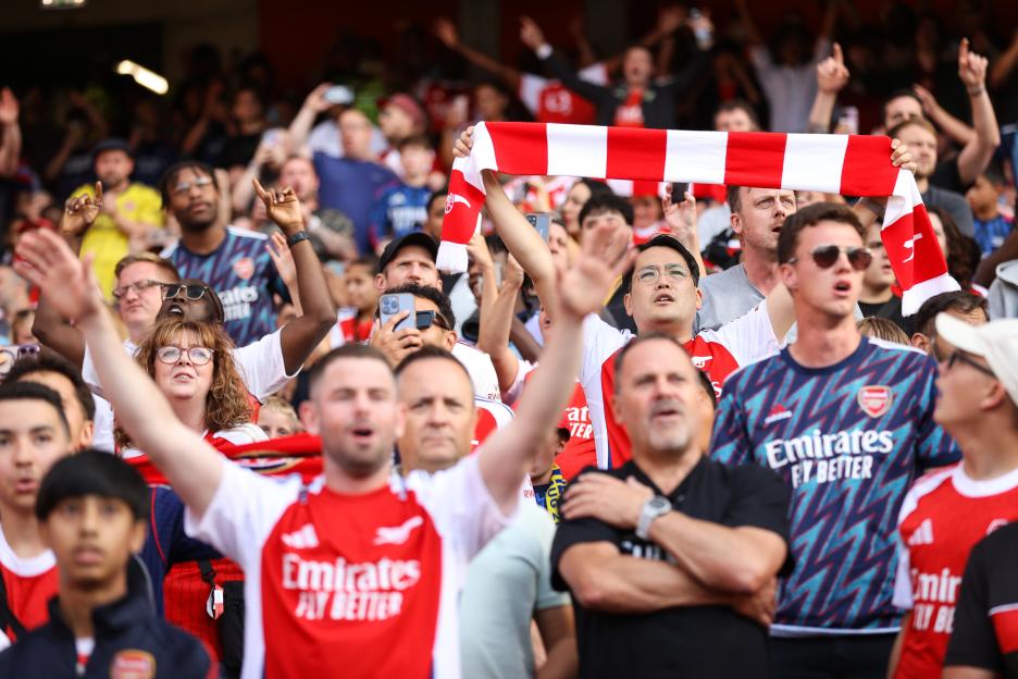 Arsenal fans cheering at a match.