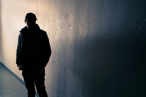 Silhouette of a suspicious man in a dark alley.