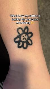 A healing flower tattoo on a person's ankle.
