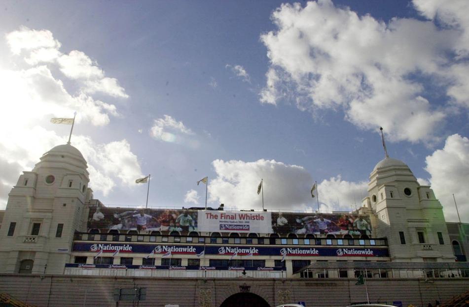 The twin towers of Wembley Stadium, with a banner reading "The Final Whistle Wembley Stadium 1923-2000" and football players.