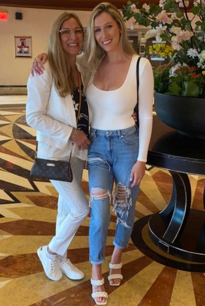 two women posing for a picture with one wearing a louis vuitton purse