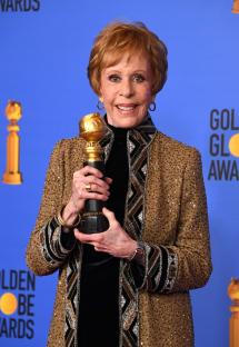 Carol Burnett holding the Golden Globe award named after her.