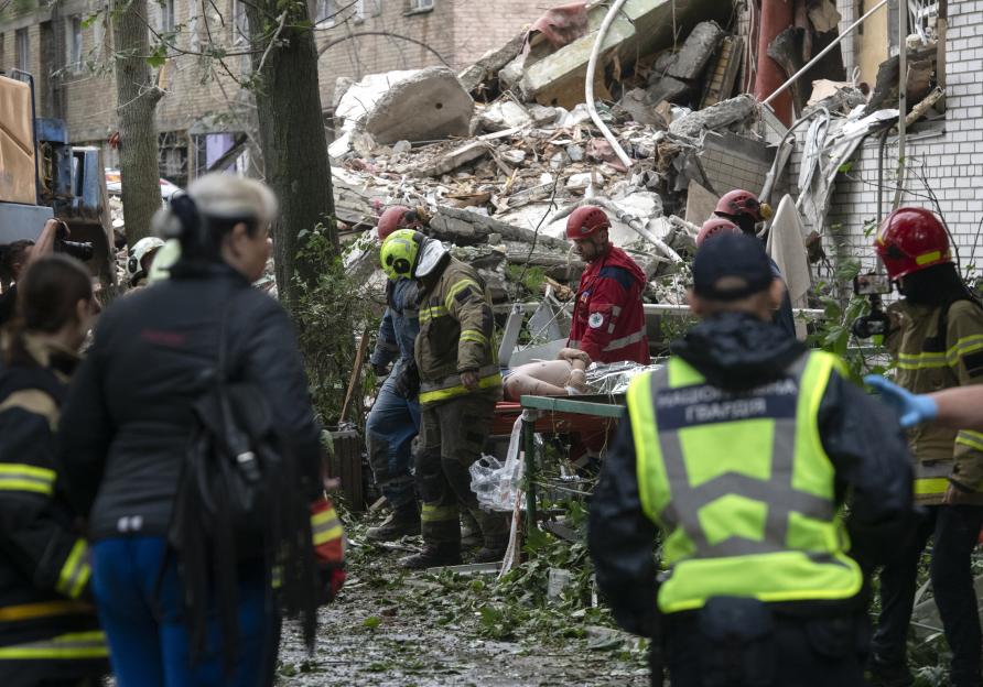 Rescuers carry a survivor from a bombed building in Kyiv.