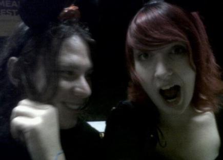 Photo of two people, one with dark hair and one with red hair, making surprised faces.