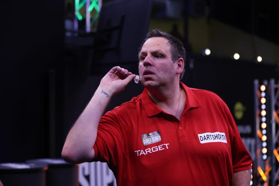 Professional darts player Adrian Lewis prepares to throw a dart.