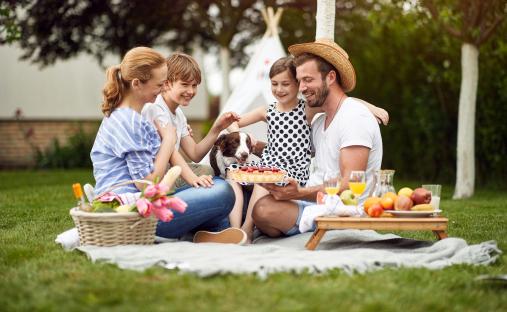Family enjoying a picnic with their dog.