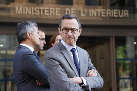 France's Minister of the Interior, Bruno Retailleau, standing with arms crossed.