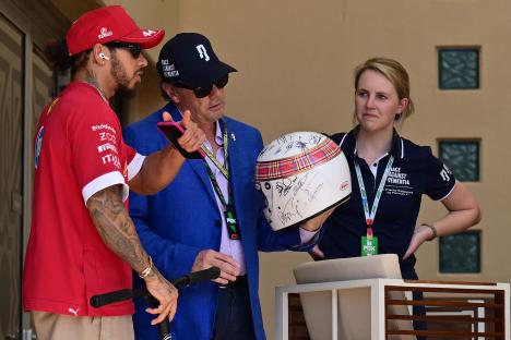 Mark Stewart showing Lewis Hamilton his father's signed racing helmet.