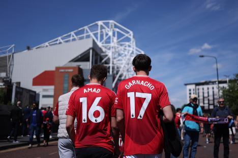 Manchester United fans wearing Amad and Garnacho jerseys outside Old Trafford.