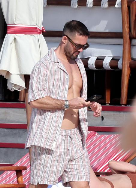 Spencer Matthews looking at his phone while shirtless.