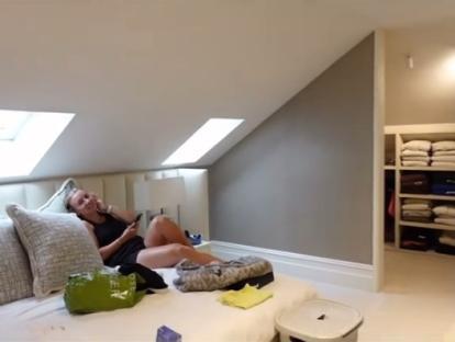 Woman relaxing on a bed in an attic room with a built-in closet.