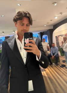 Man in black tuxedo taking a selfie.