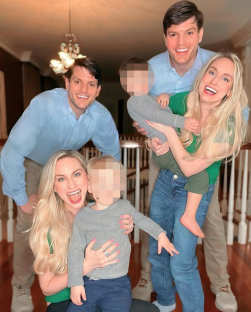 a group of people posing for a picture with one of them holding a child