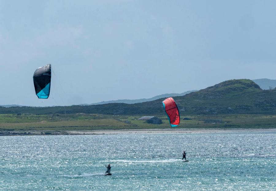 Two people kitesurfing in Gott Bay, Isle of Tiree, Inner Hebrides, Scotland.