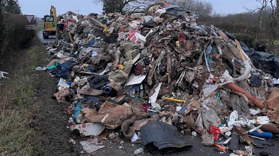 Man and company charged after 27 TONNE mountain of rotting rubbish dumped in road bigger than two double-decker buses