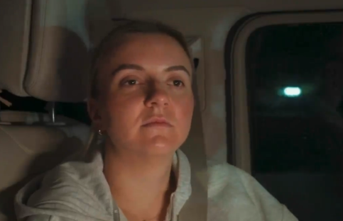 Woman sitting in a car at night.