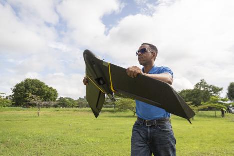 A man holding a fixed-wing drone.