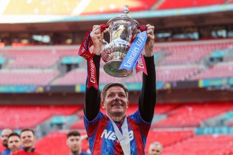 A Crystal Palace coach lifts the FA Cup.