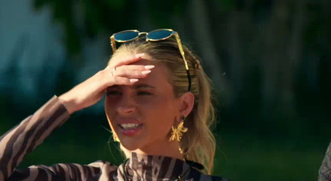 Woman shielding her eyes from the sun with her hand.