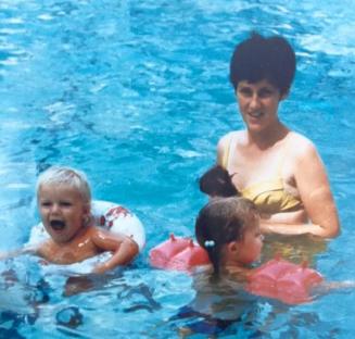 Woman and two young children in a swimming pool.