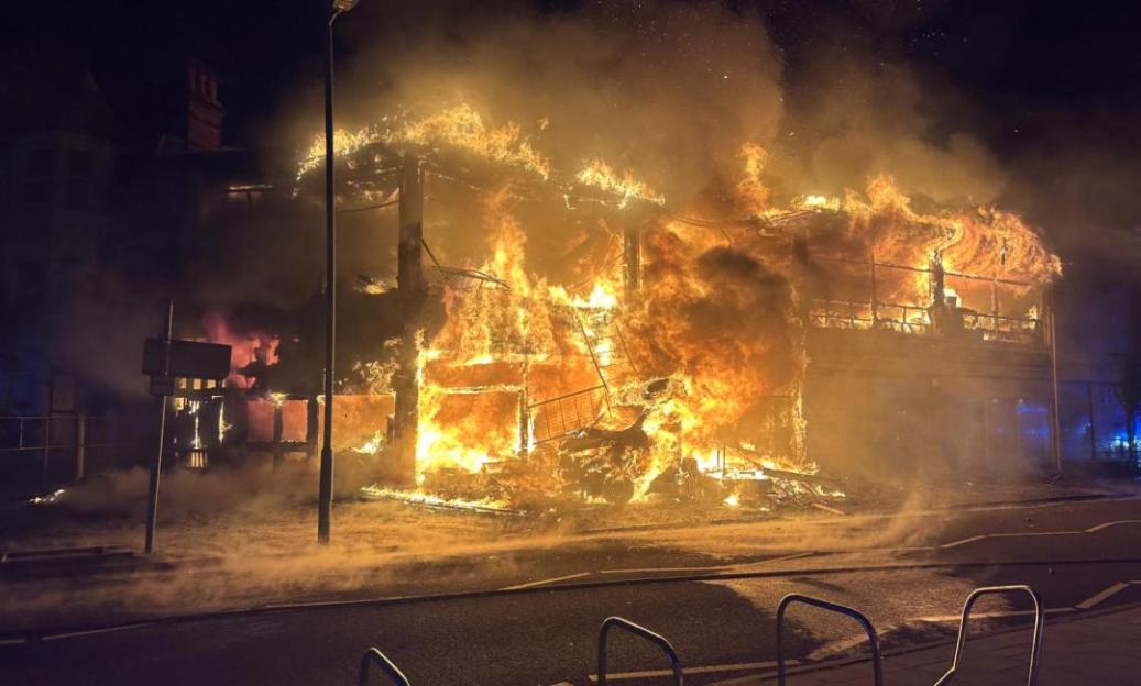 Building engulfed in flames at night.