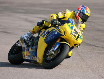 Motorcycle racer leaning into a turn.