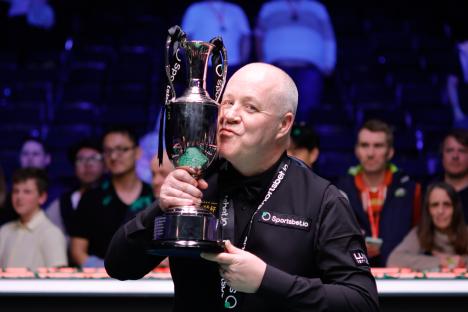 John Higgins of Scotland kissing his trophy after winning a snooker tournament.
