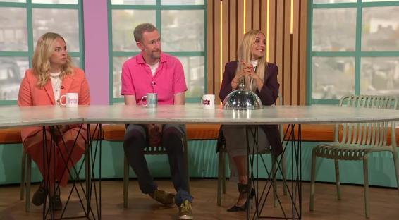 Three people sitting at a table on a television show.