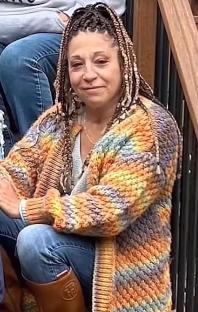 Photo of a woman in a multicolored cardigan.